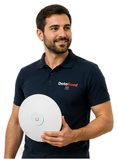 Homme barbu portant un polo bleu marine tenant un appareil sans fil blanc et rond avec un anneau bleu et un bouton ' U ', portant un polo avec le logo DotaRoad.